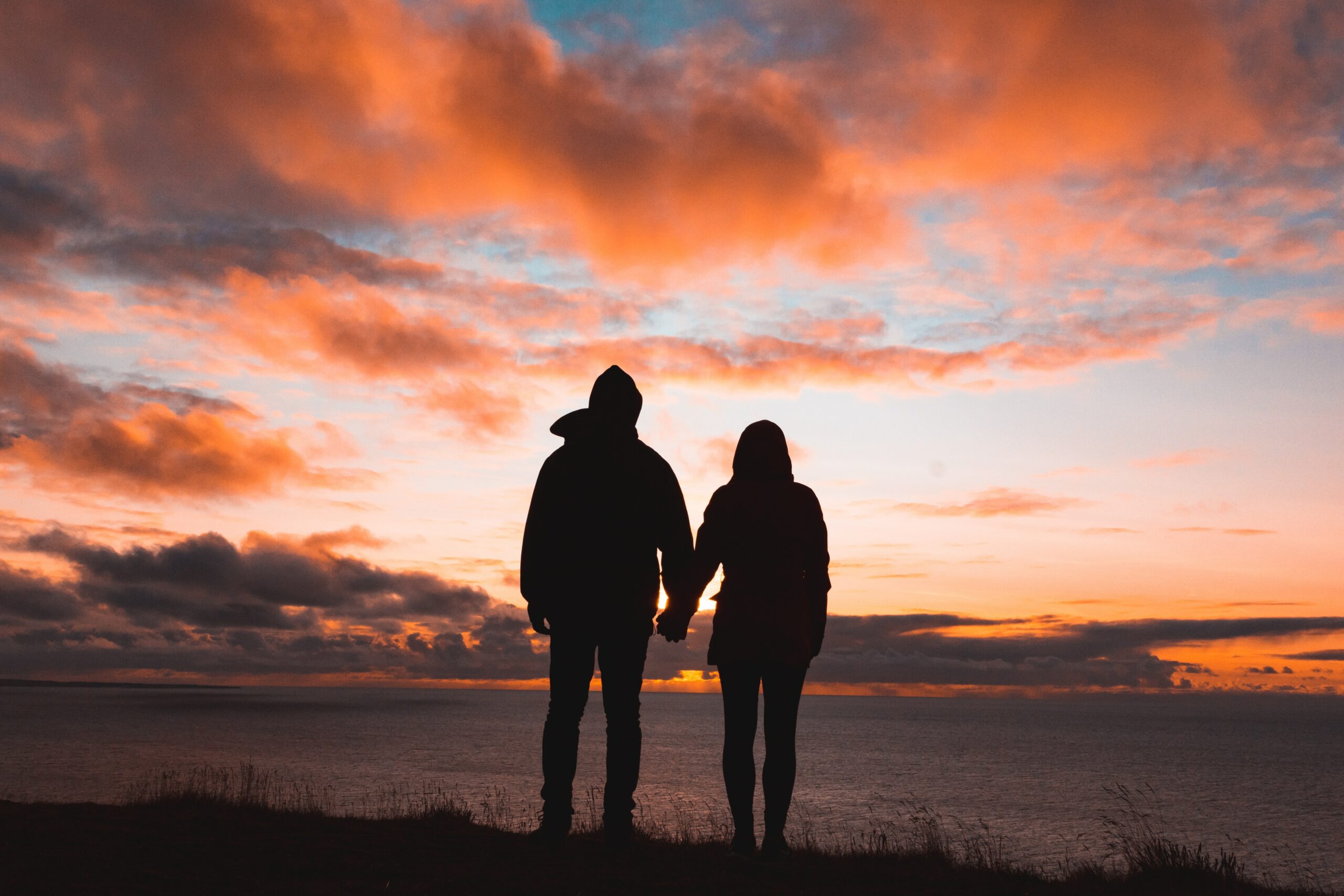 two people silhouette holding hands
