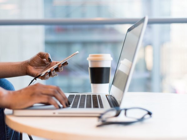 A person with their phone connected to their laptop, maybe to share a large file with someone.