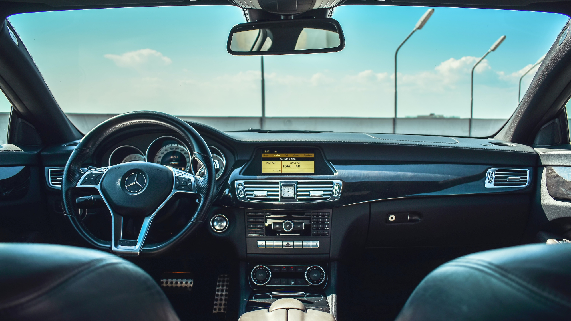 The inside of a parked car on the top floor of a parking garage, baking in the heat.