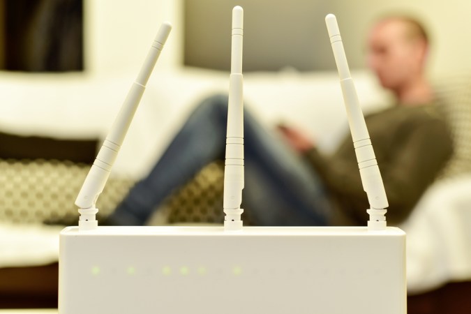 White wireless router in front of person on a couch