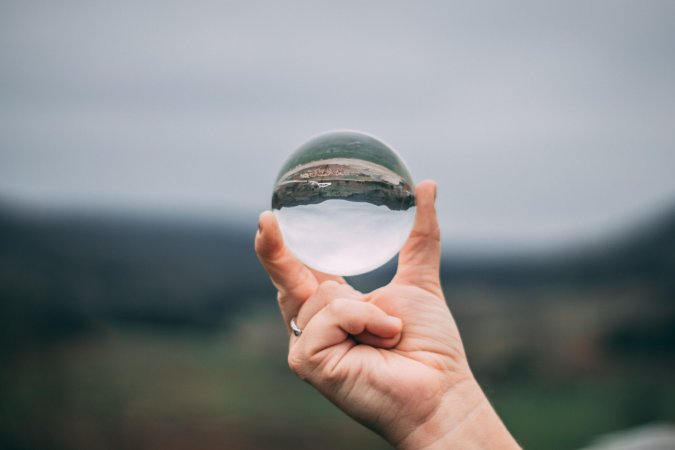 a hand holding a glass sphere