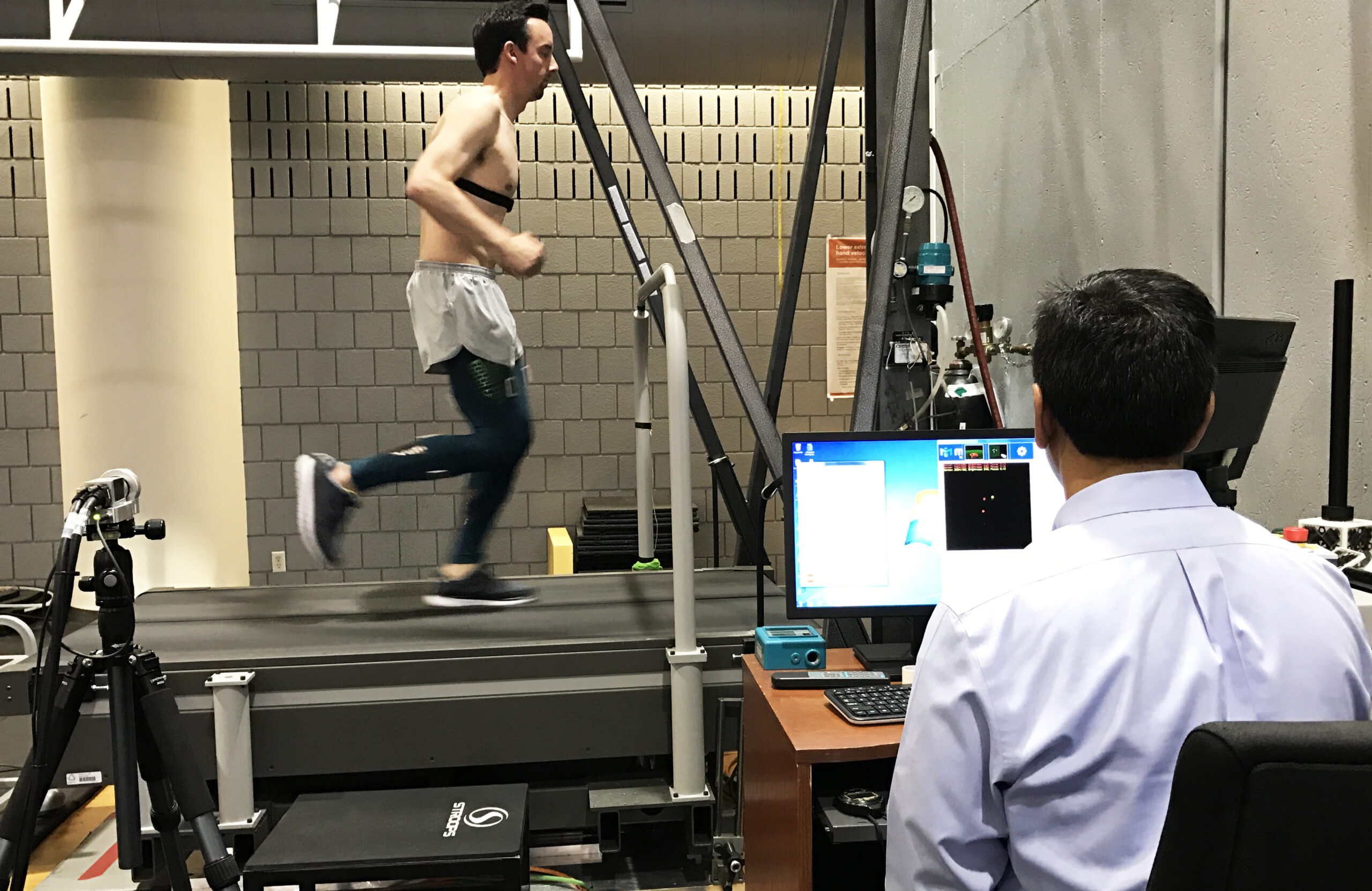 runner on a treadmill during an exercise study under a scientist's supervision