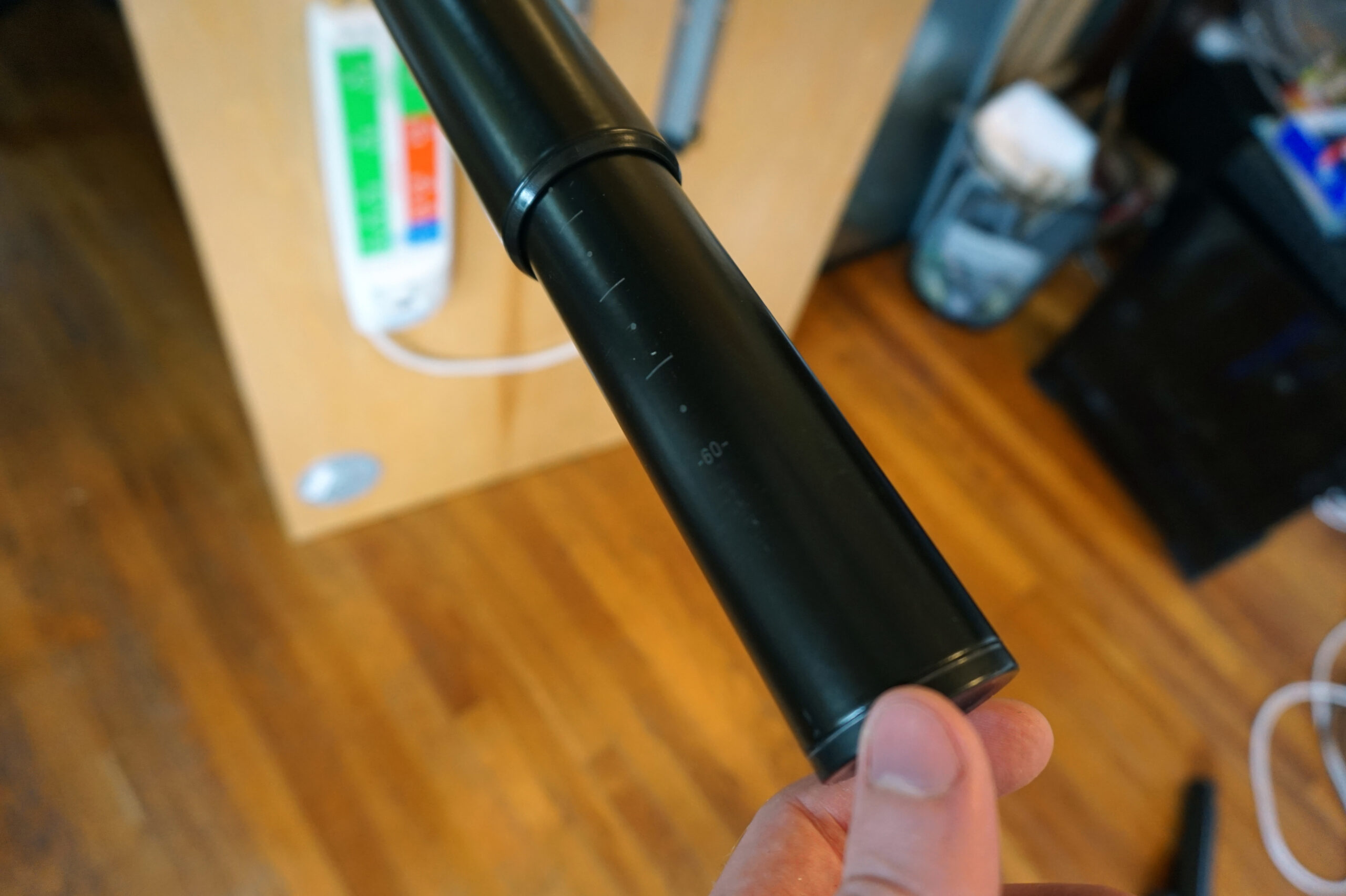 A person fastening legs onto the main part of a DIY computer desk.