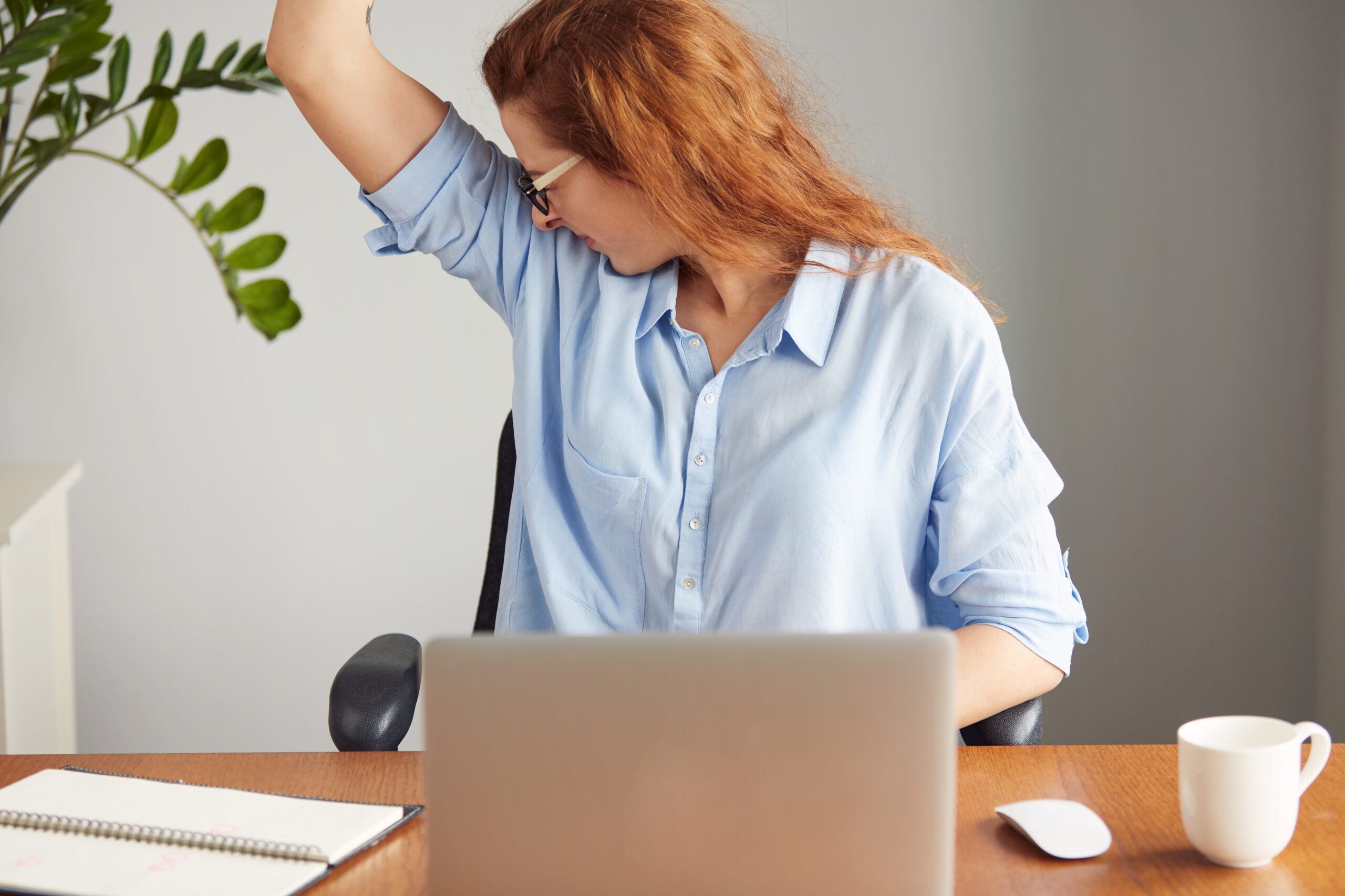 a woman sniffs her armpit