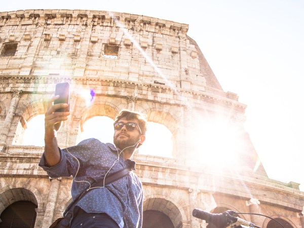 man snapping selfie in front of the Colisseum