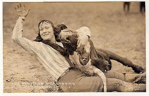 a woman wrangling a cow