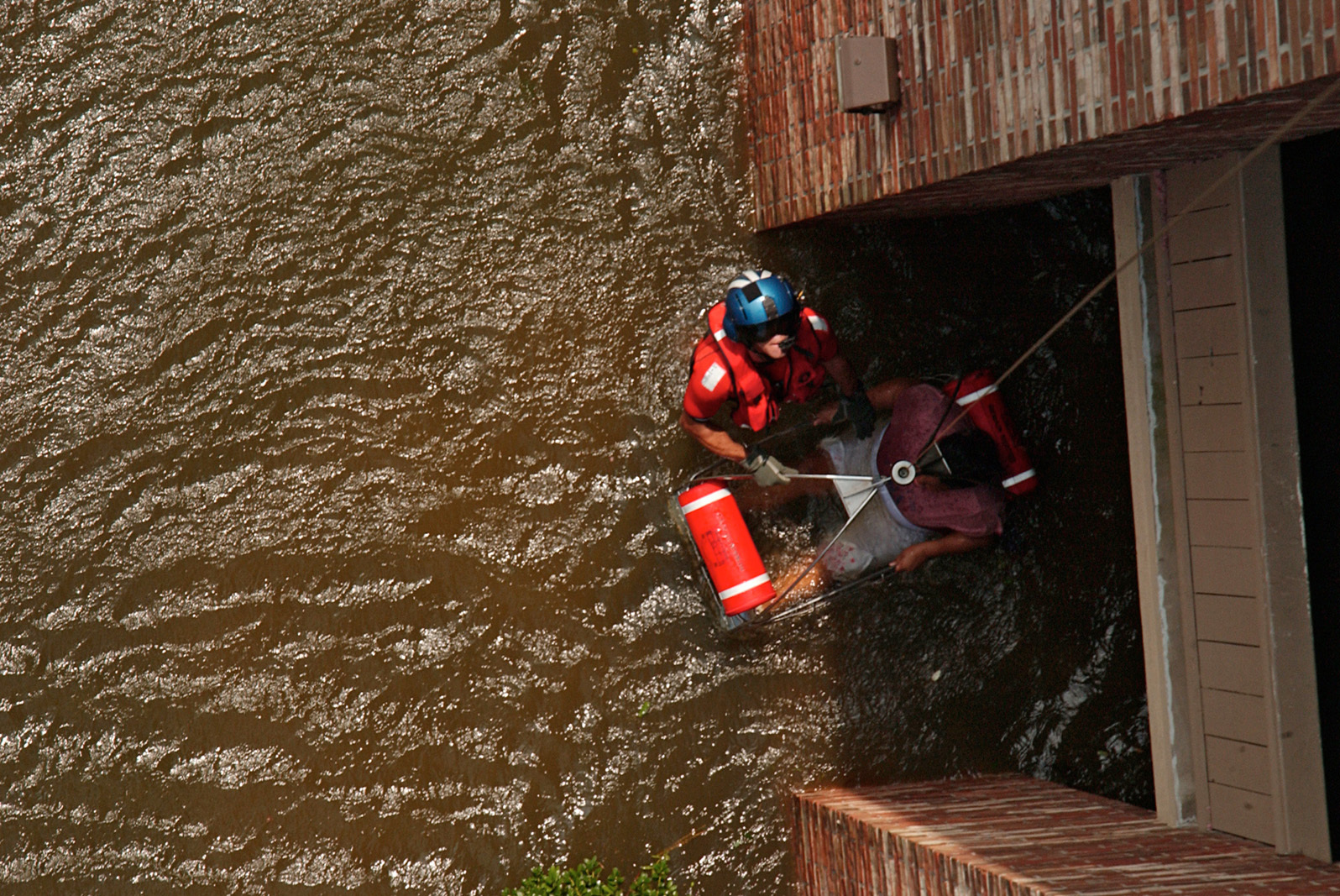 Coast Guard officer pulls a pregnant woman from her flooded home