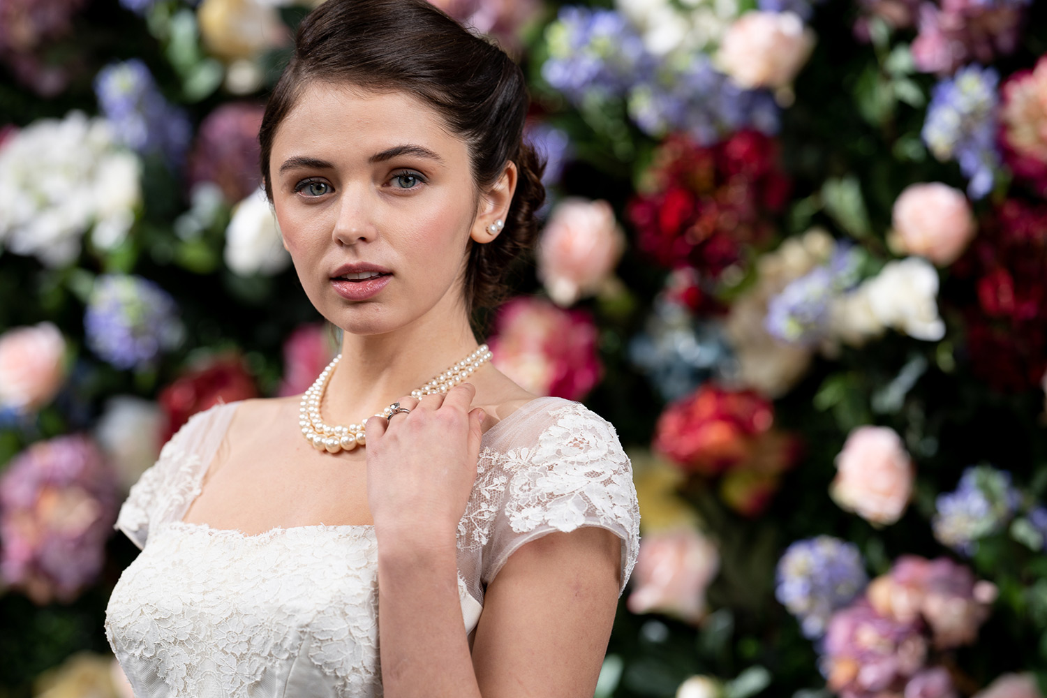 model in white against flower wall