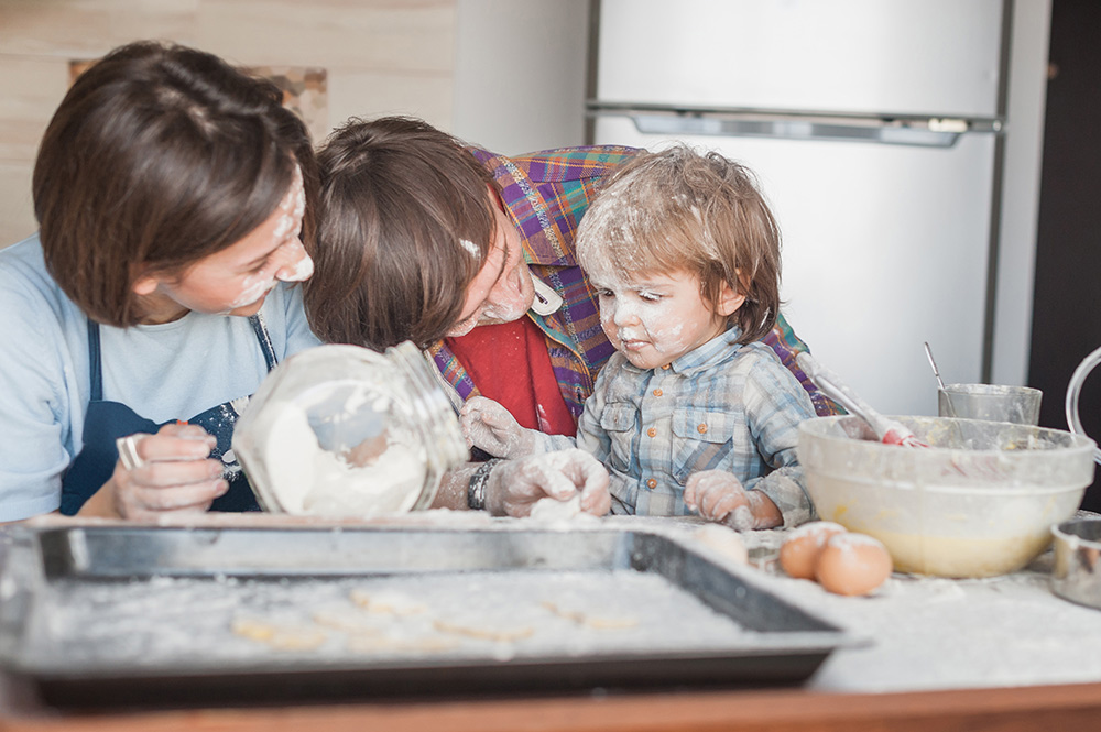 family covered in flour while baking