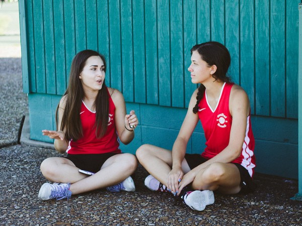 teen girls sitting cross-legged on the ground