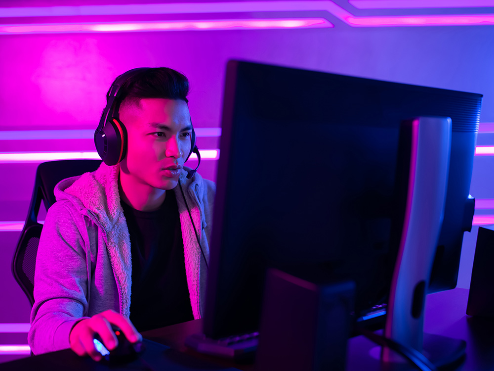 teen playing video games in the dark