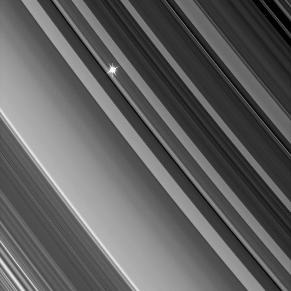 star shines through saturn's rings