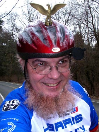 Sheldon Brown wearing a red bike helmet and a blue-and-white cycling shirt.