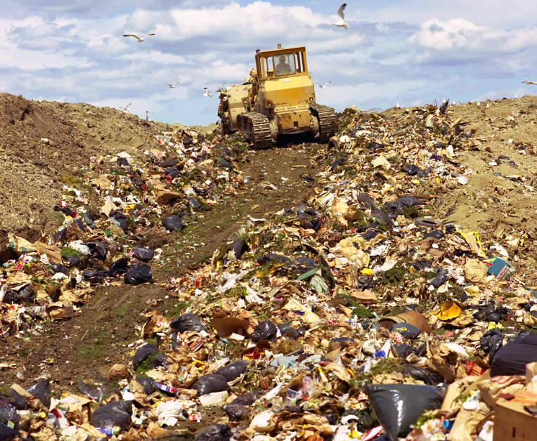 excavator driving over a dump yard