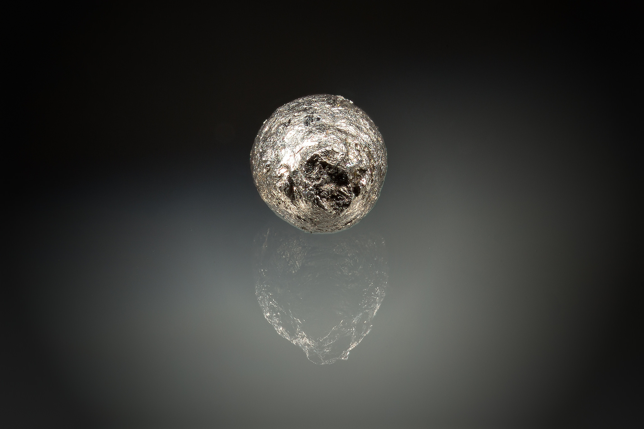 An isolated micrometeorite about 0.5 mm in diameter.