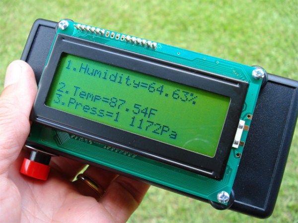 A handheld electronic device with a green LCD screen showing the temperature and humidity outside.