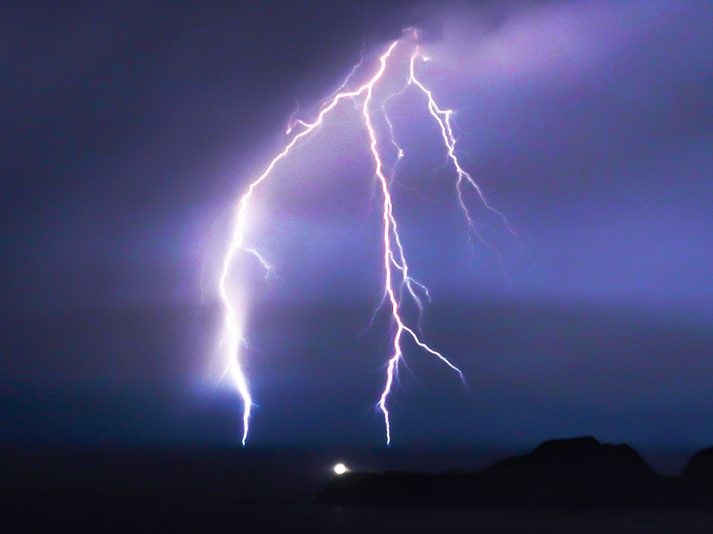 bright lightning against purple sky