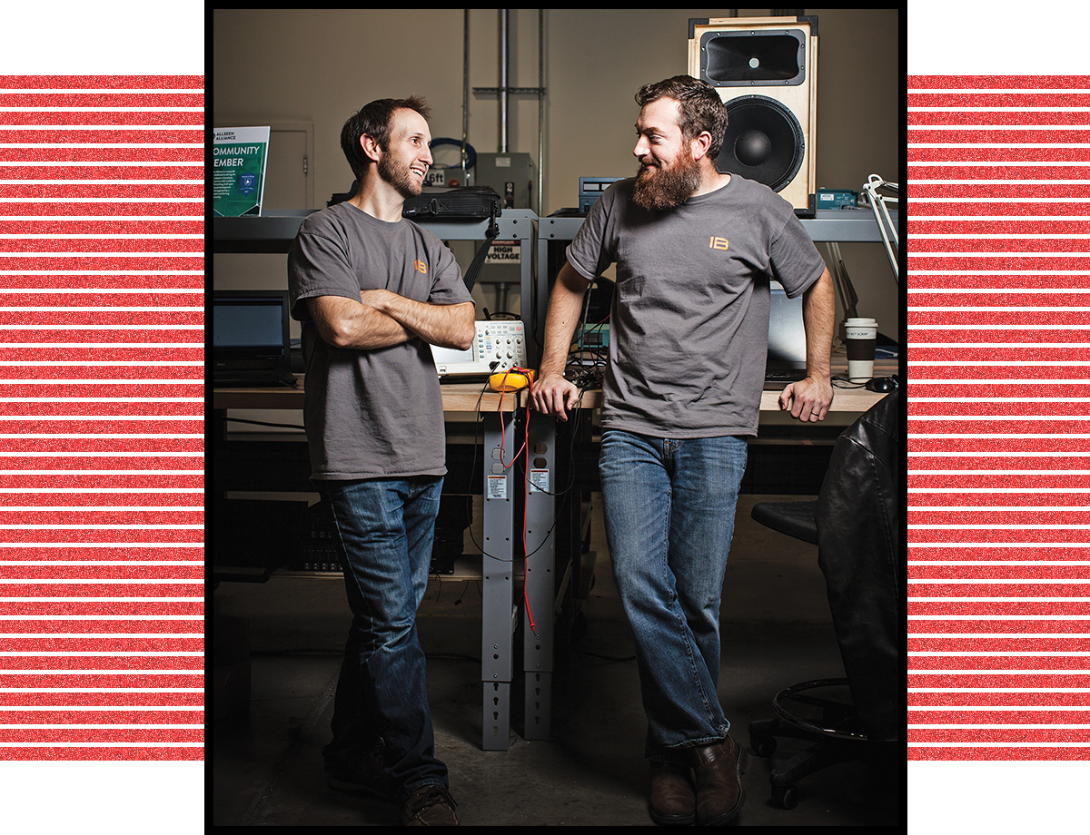 Engineers Justin Brown and Tim Gillespie talk in front of an audio speaker