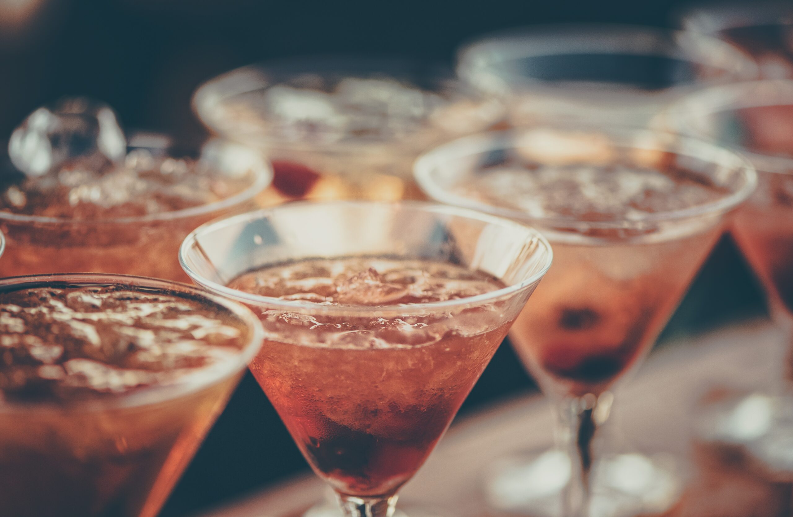 Pink alcoholic beverages in triangular glasses. 