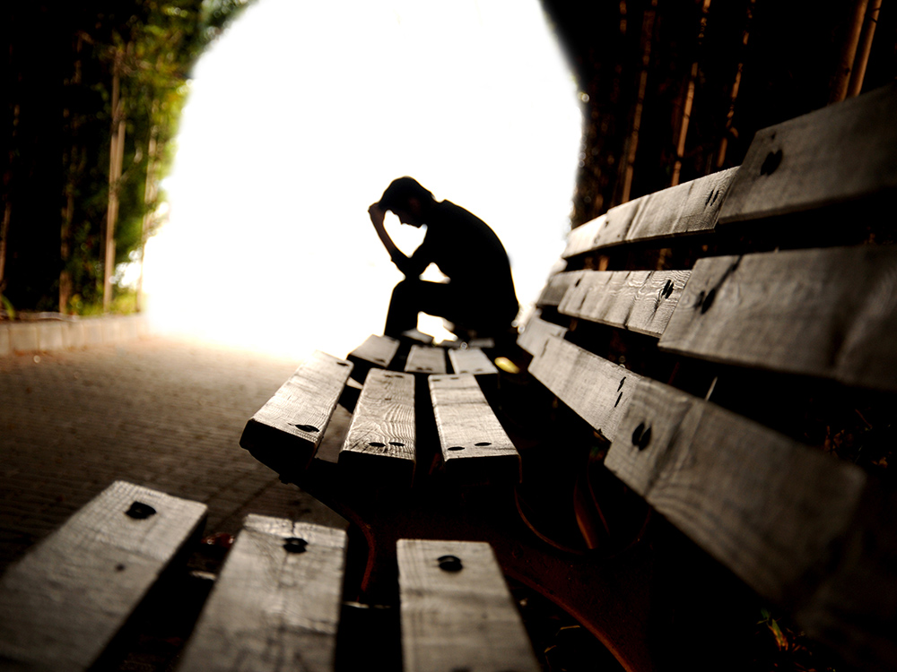 silhouetted man on bench