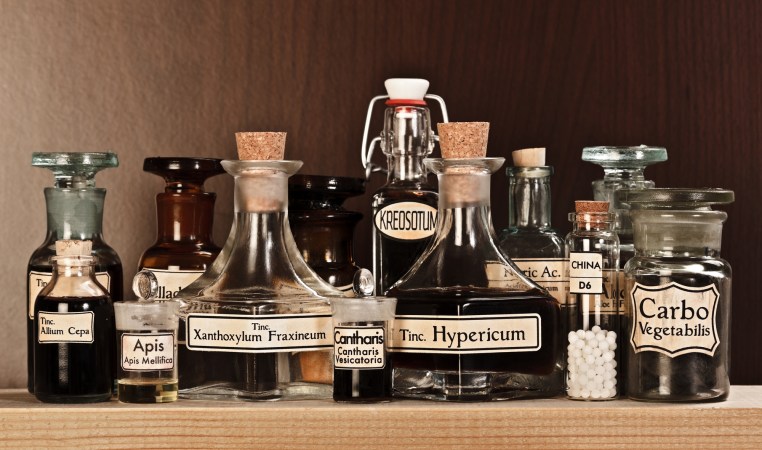 glass bottles on a shelf with handwritten labels