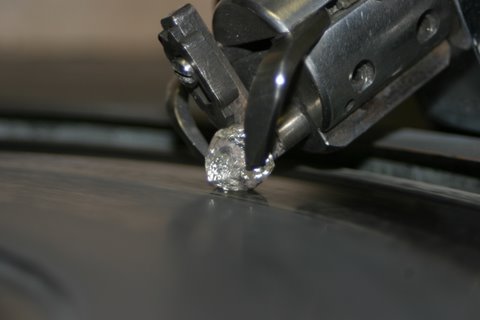 A lab-grown diamond gripped by a machine