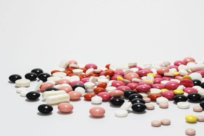 Black, white, and pink pills on white background