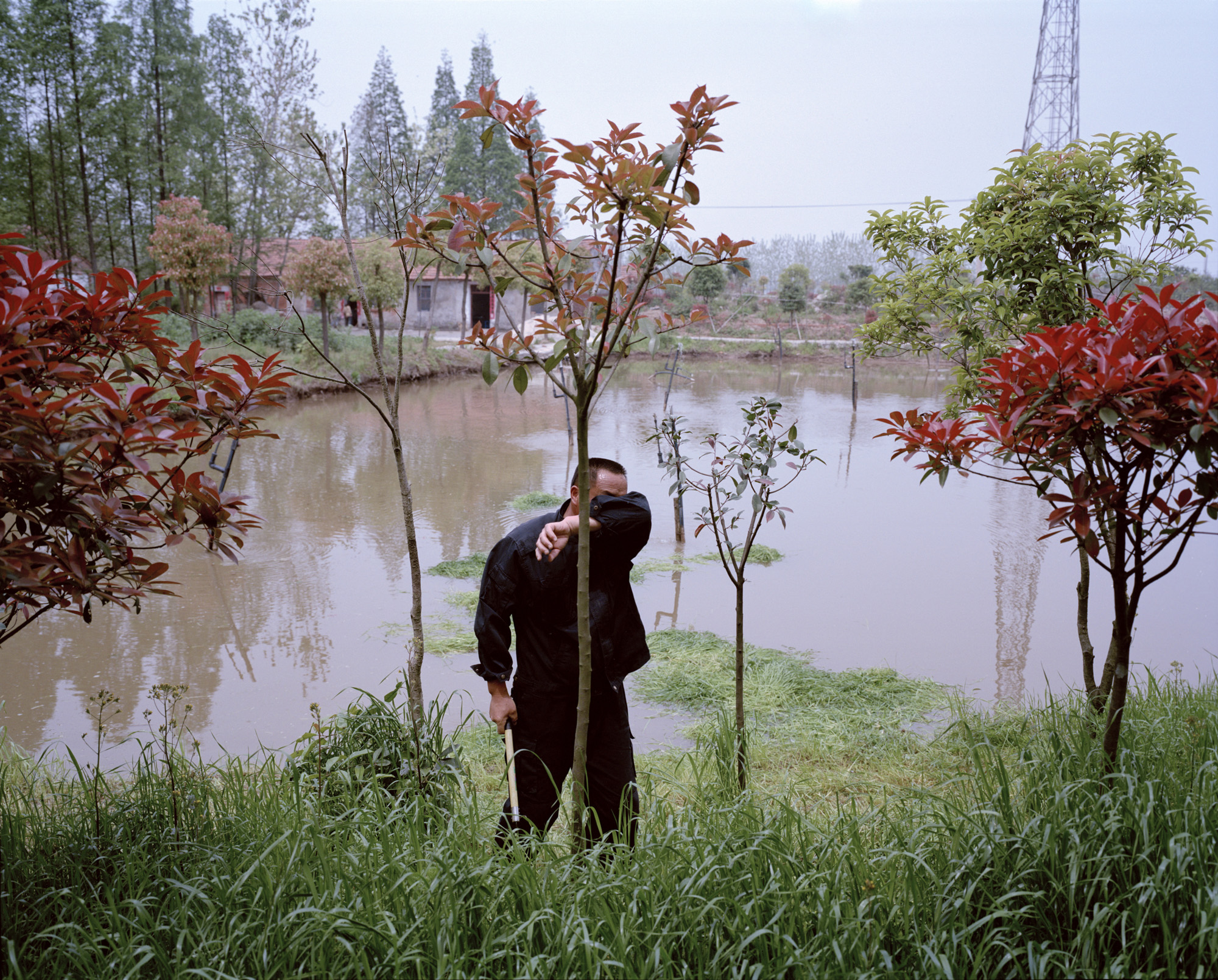 a man wiping sweat off his forehead at a Chinese fishery