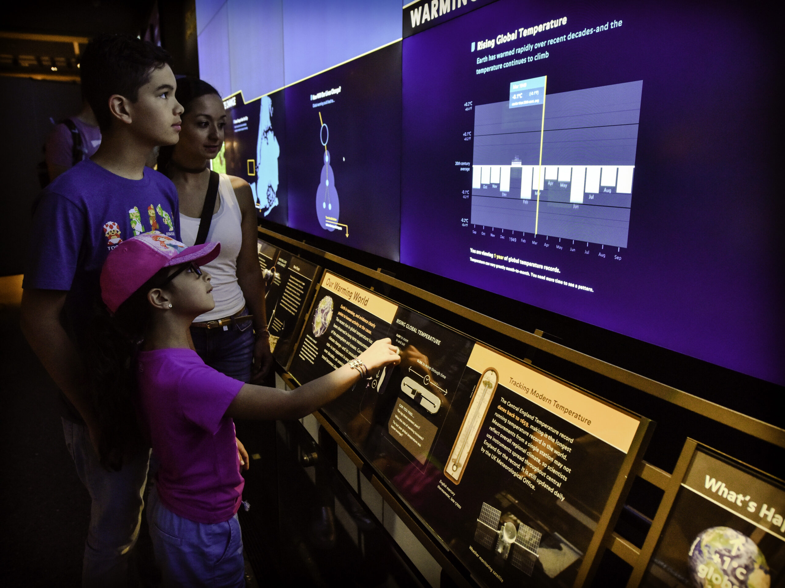 a family gathered around a large touch screen