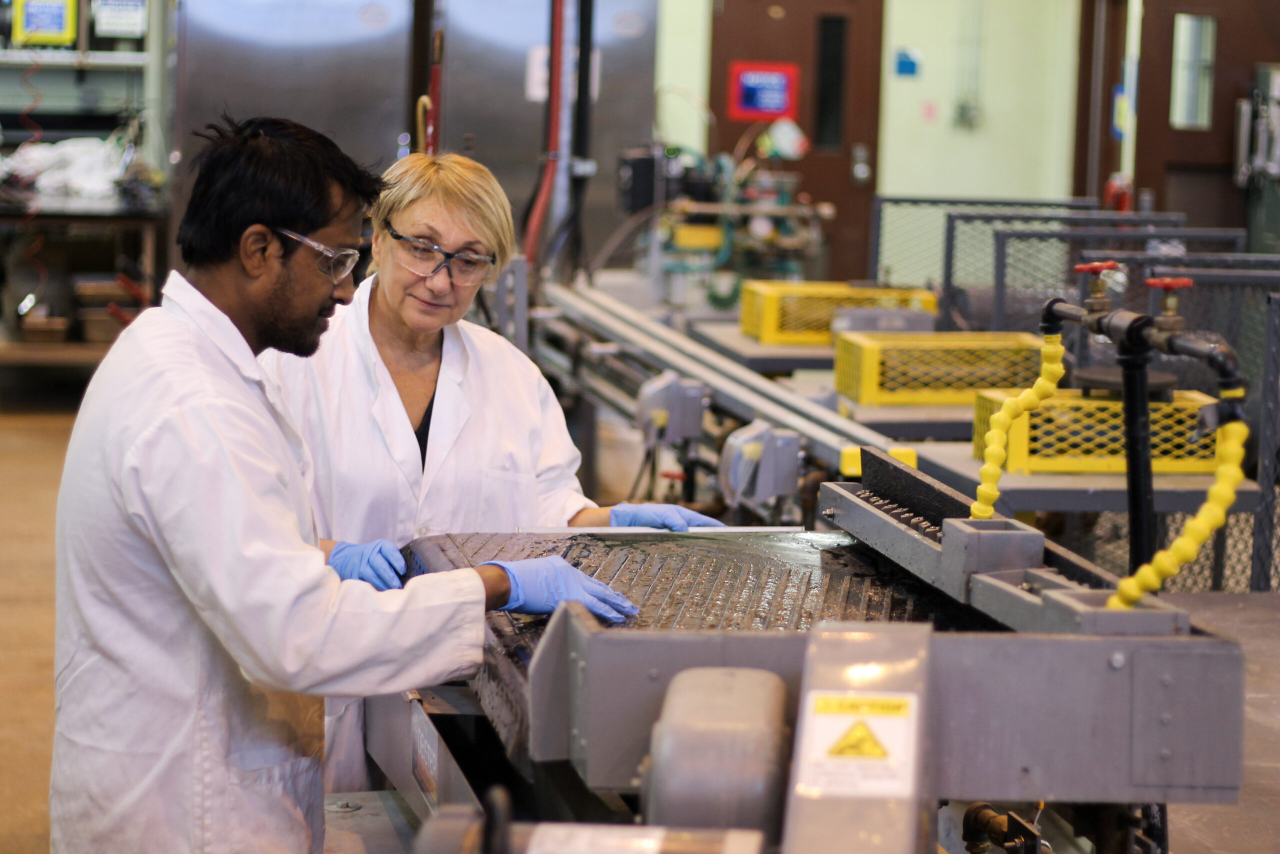 Amit Kumar and Maria Holuszko operate a device that uses gravity to separate the materials that make up cell phone circuit boards.