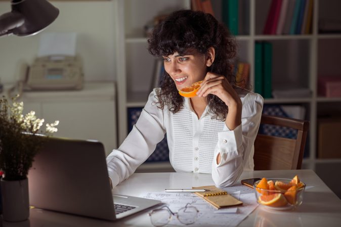 a woman working on her laptop at night