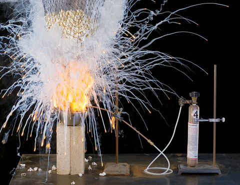 An explosion of fire and smoke creating table salt to season a bag of popcorn in a lab.