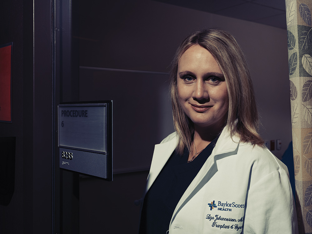 Surgeon Liza Johannesson wearing scrubs and a white coat