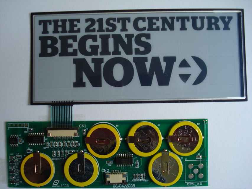 The Esquire e-ink cover components removed from the magazine, showing a screen that reads "The 21st Century begins now :)" and a connected circuit board.