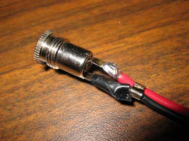 A pluggable cylinder connected to a red and a black wire.