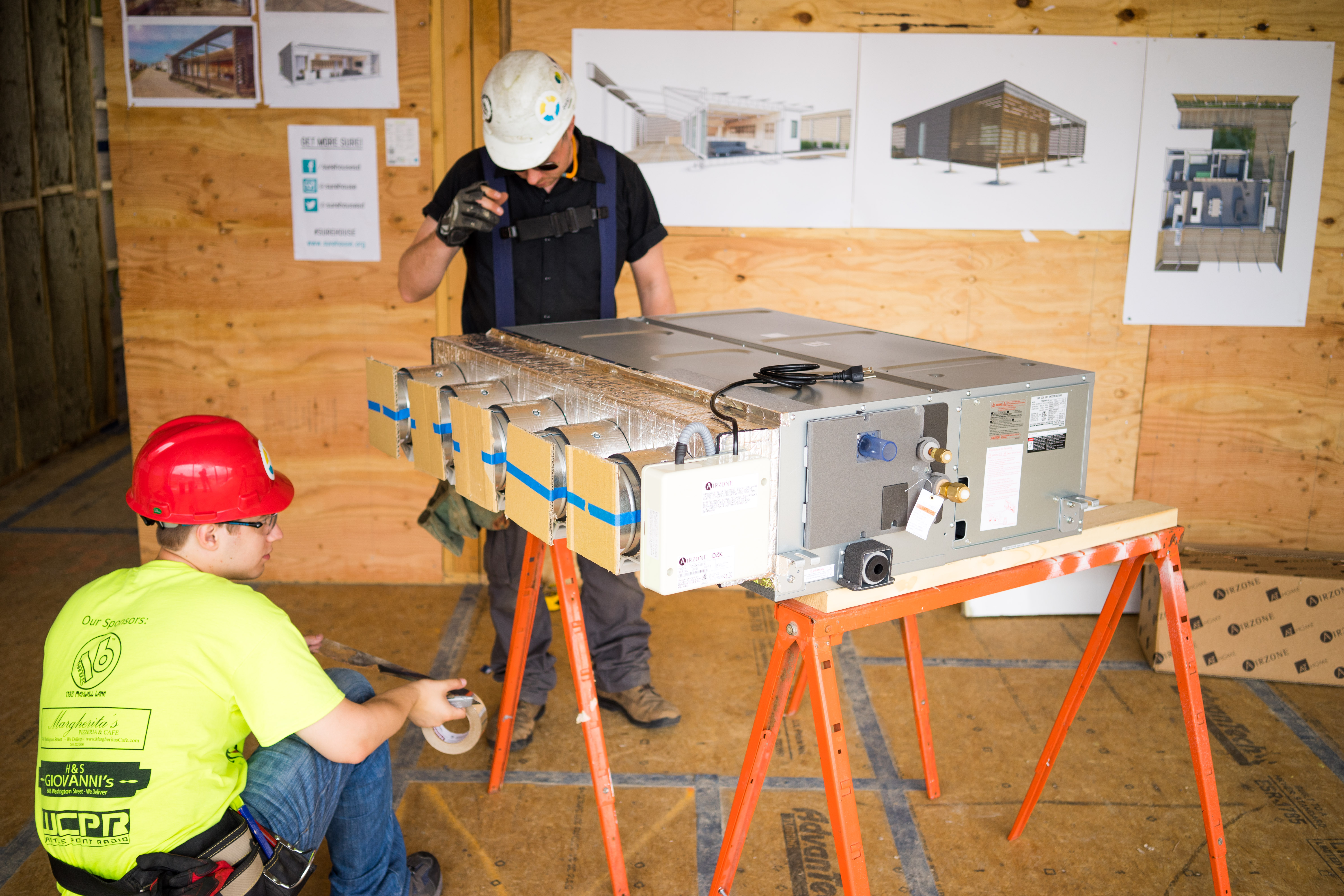 central air handling unit on a building site with two workers