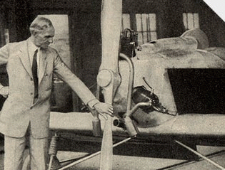 An old man admiring an airplane with his hand on the propeller