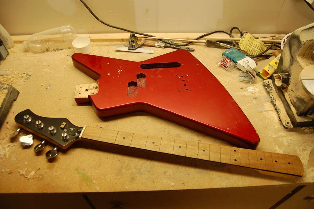 Parts of an electric guitar on a workbench.