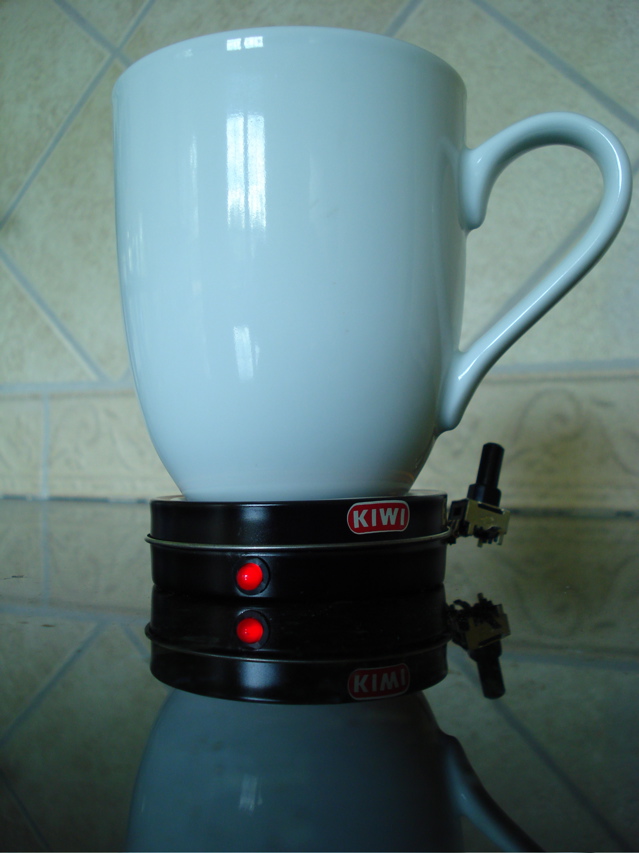 A white mug on top of a smart coaster with red LEDs.