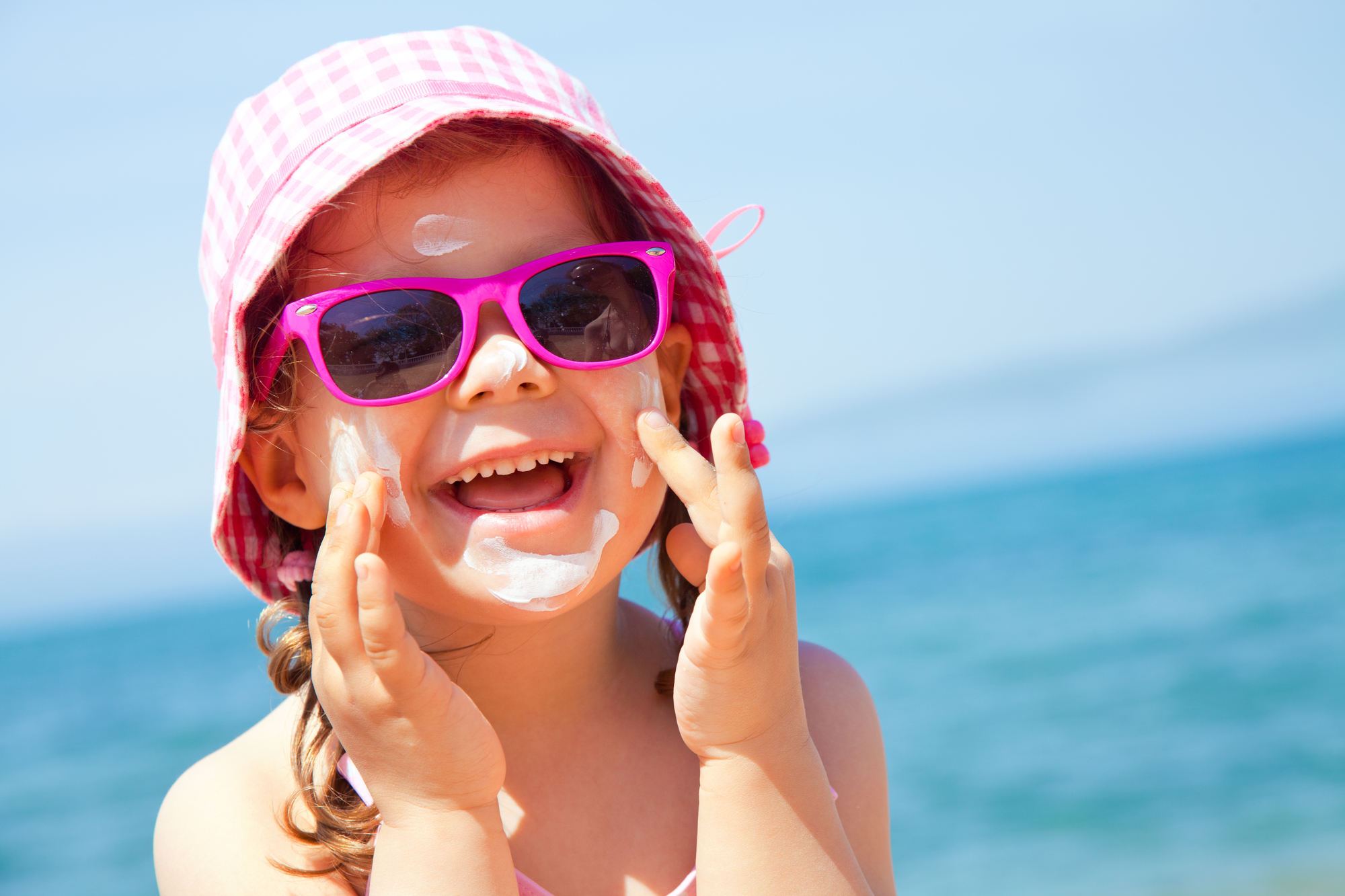 kid applying sunscreen