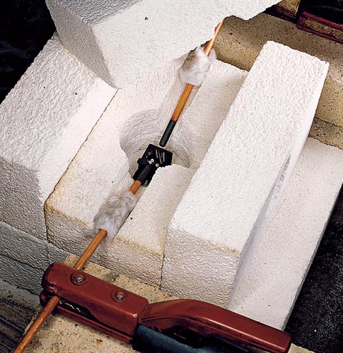 A furnace made out of white firebrick with a tungsten rod in the center.