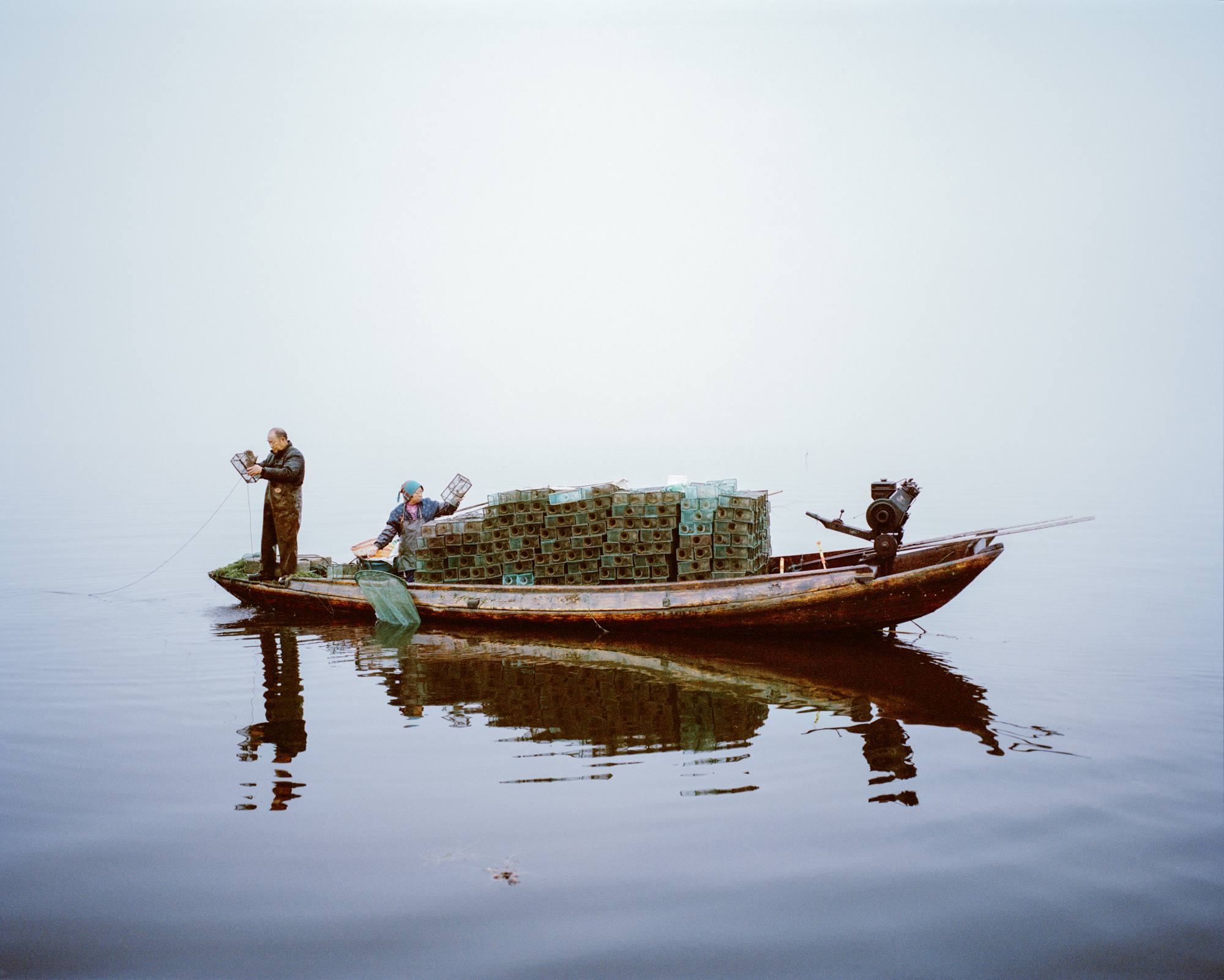 Chinese man shrimp fishing from his boat at Lake Hong