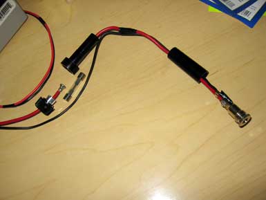 A red cable with black ends on a desk.