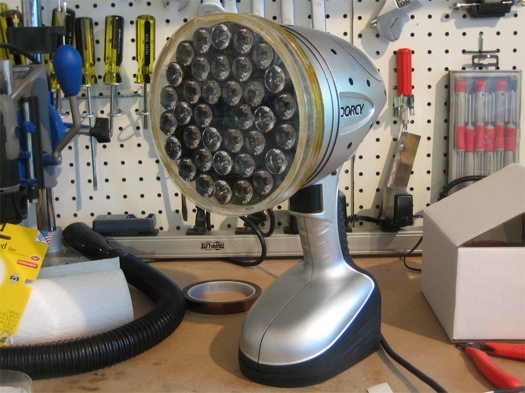 A handheld "bedazzler" with LEDs that can disorient people, sitting on a workbench.