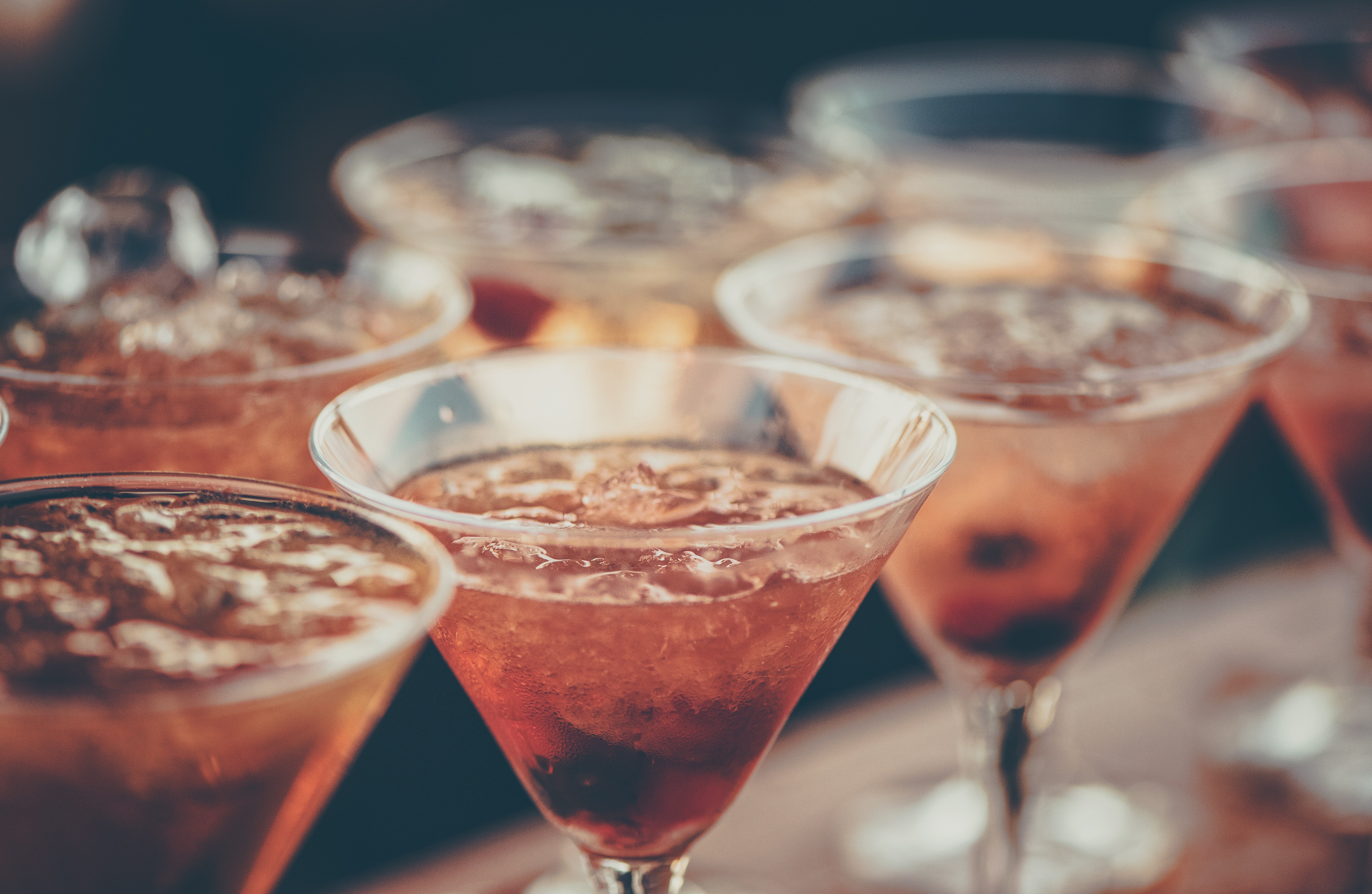 Pink alcoholic beverages in triangular glasses.