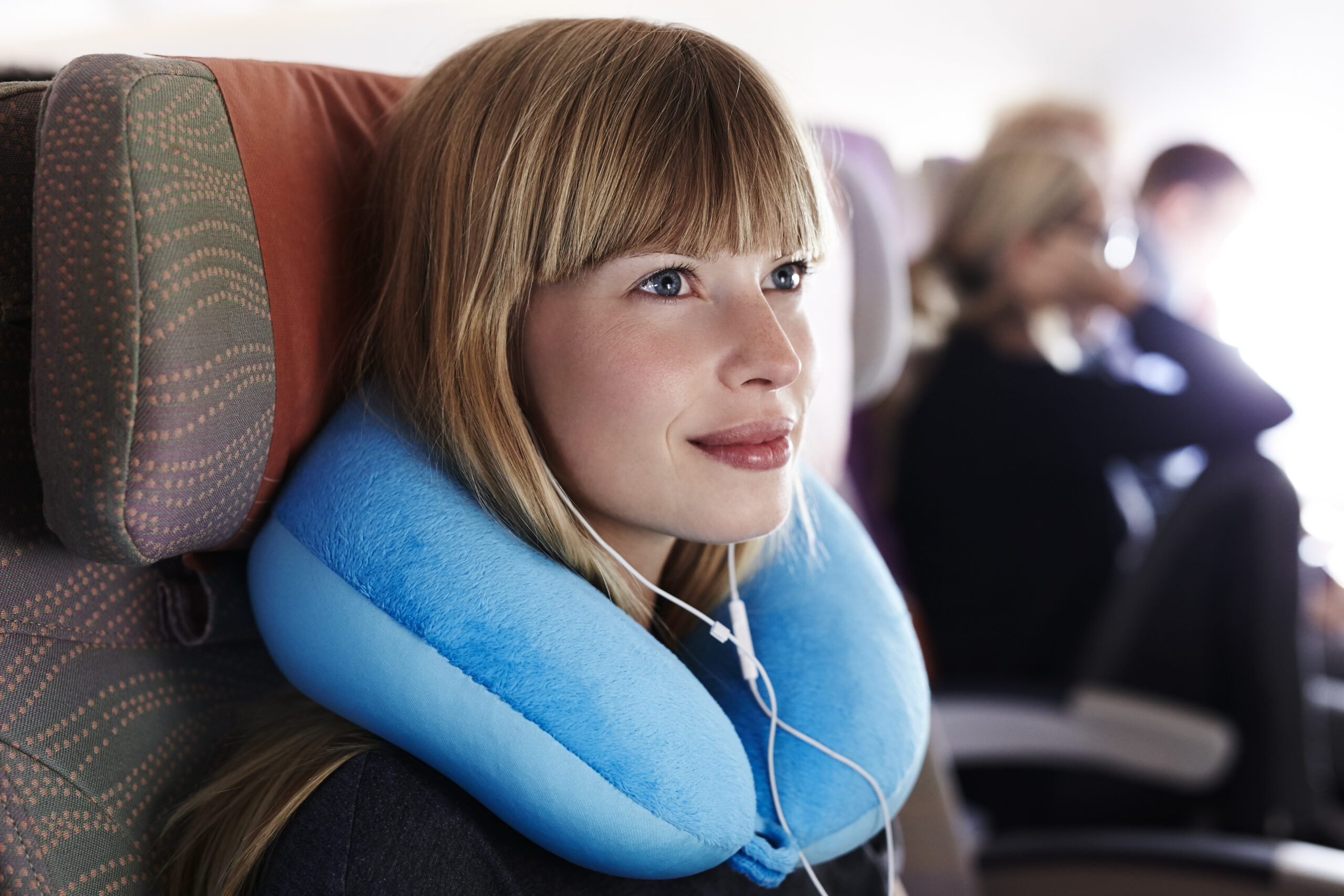 woman with neck pillow on plane