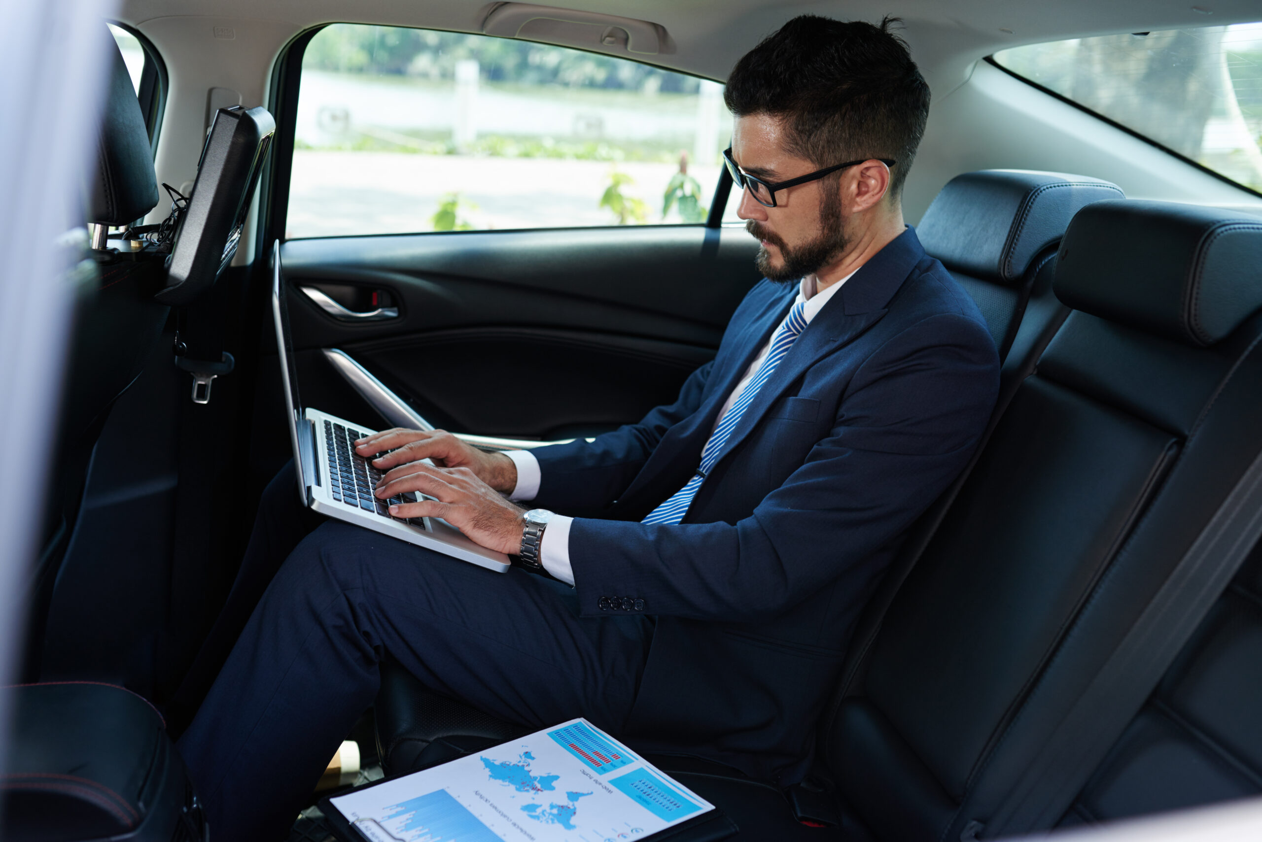 man using laptop in car