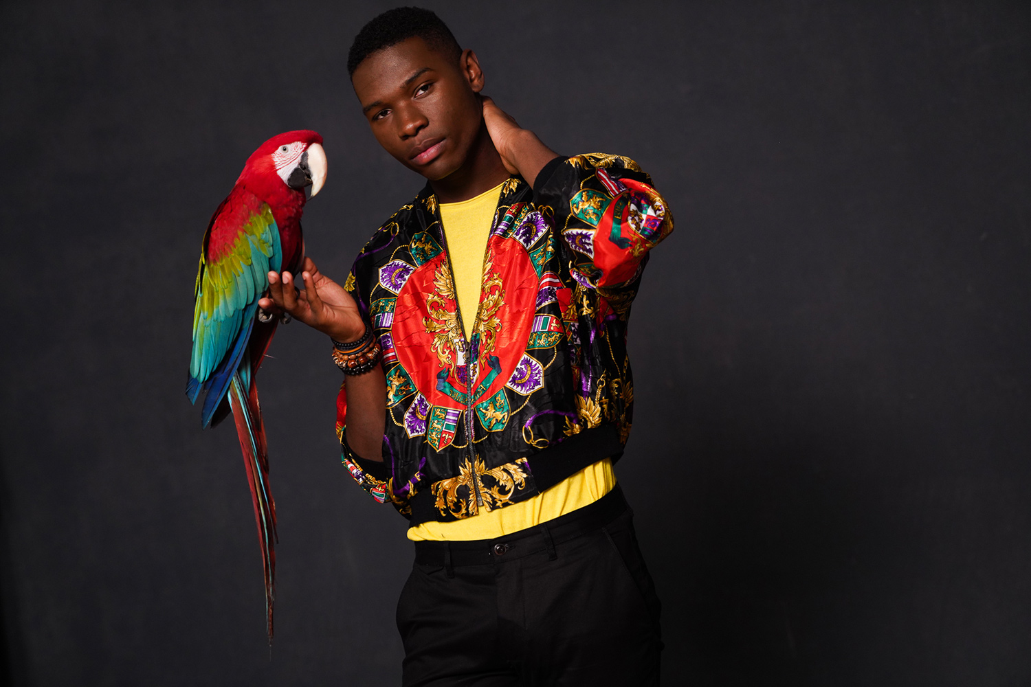 man in colorful jacket with macaw