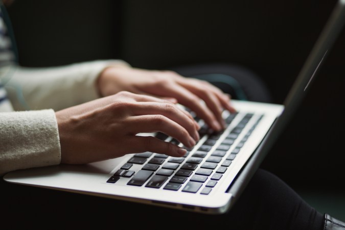 Hands typing on a laptop.