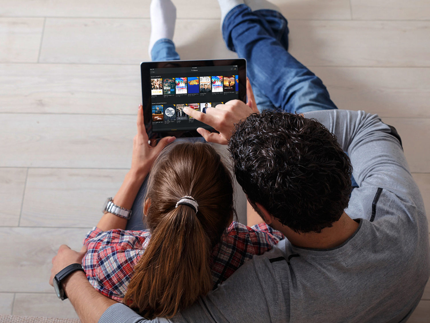 Man and woman sitting on the floor watching a tablet